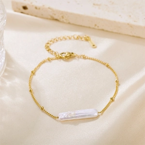 Baroque freshwater pearl bracelet with thin gold chain and adjustable clasp on silk backdrop