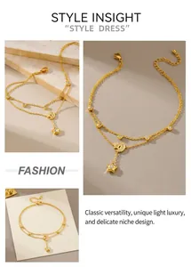 Détail d'une chaîne de cheville double dorée avec pendentifs étoile et lune et cristaux
