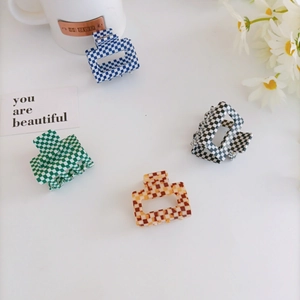 Set of four checkered acrylic hair claws in green, blue, black, and amber brown colors