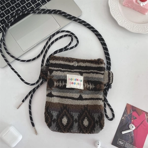 Detail of plush crossbody bag with ethnic patterns and adjustable woven shoulder strap
