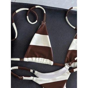 Detailed flat lay of brown and white striped bikini with decorative metal ring buckle