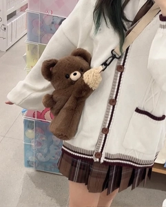 Detail of cute plush teddy bear crossbody bag with soft faux fur texture and beige strap