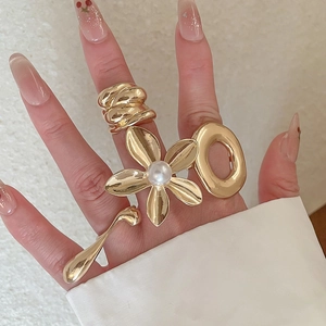 Detailed close-up of a stylish gold-plated floral pearl and teardrop ring set for women