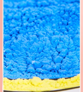 Macro texture detail of bright blue 3D puffy paint with unique popcorn expansion effect