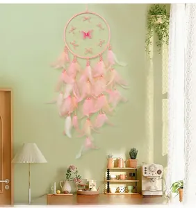 Detail of handmade pink dream catcher with feather charms and butterfly decor