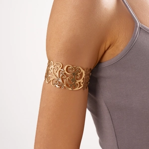 Dettaglio ravvicinato di un bracciale dorato con intricati motivi floreali