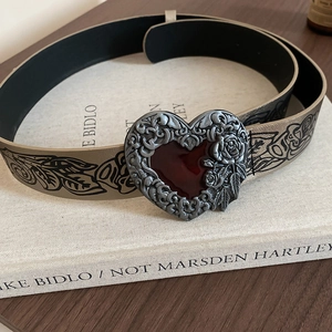 Macro view of vintage heart buckle with rose relief and floral printed belt strap