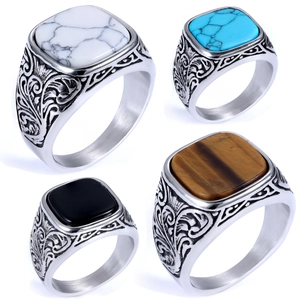 Detailed macro view of retro square turquoise rings with ornate engraved metal patterns