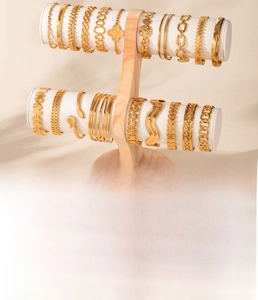 Detail of diverse gold titanium steel bracelets with snake and geometric patterns