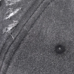 Close-up of distressed cotton baseball cap with embroidered eyelets and frayed details