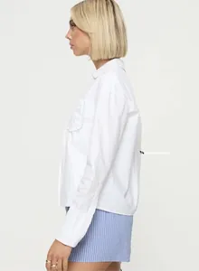 Détail du chemisier blanc à manches longues avec col classique et texture en coton fin