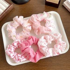 Flat lay of pink floral and polka dot lace scrunchies on a wooden table display