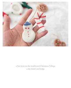Close-up of handmade wool felt snowman and candy cane Christmas tree hanging decorations