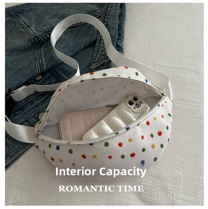 Internal capacity of the polka dot crossbody bag showing phone and wallet storage