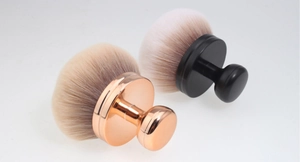 Detail of mushroom-shaped makeup brushes with rose gold and black ergonomic handles