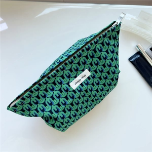 Detail of green and blue geometric pattern cotton makeup bag with silver zipper