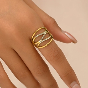 Fashionable hollow geometric gold ring with diamonds on model's hand in soft light