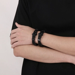 Detail of black braided leather bracelets with secure magnetic metal clasp on wrist