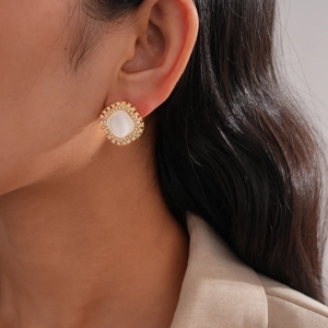Macro side view of vintage square stud earring with white stone and diamond halo