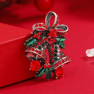 Christmas bell brooch with red rhinestones on holiday gift box backdrop