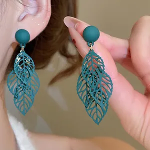Green hollow leaf tassel earrings with matte silver pins in a neo-Chinese aesthetic
