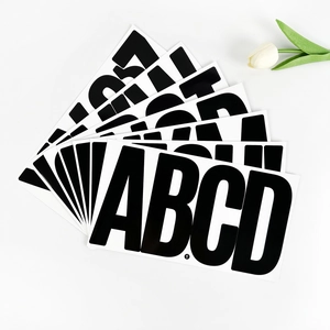 Close-up of waterproof 6-inch vinyl letter stickers in bold black and white font