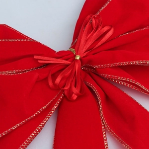 Detail einer roten Samt-Weihnachtsschleife mit Golddrahtkanten und Plüschstruktur