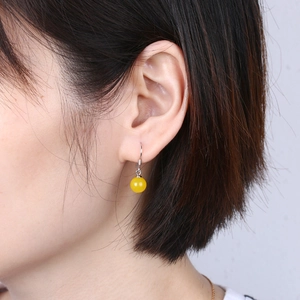 Detail view of a yellow agate bead earring worn on ear with S925 silver hook