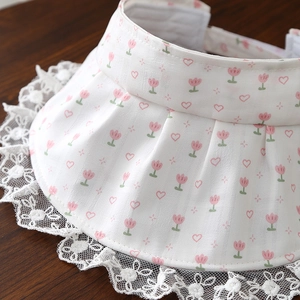 Gros plan d'une visière bébé avec tulipes roses, imprimé cœurs et bordure en dentelle