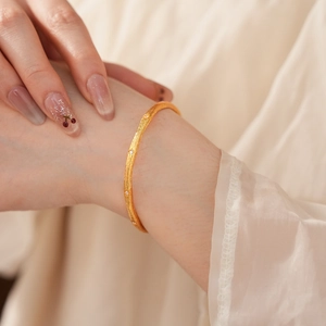 Close-up of a vintage brushed gold bracelet with small diamonds on a model's wrist