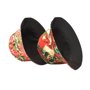 Reversible bucket hat with abstract red and green print and black inner lining for sun protection