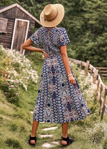 Vue de dos d'une robe midi bleue à imprimé fleuri avec taille cintrée et style champêtre