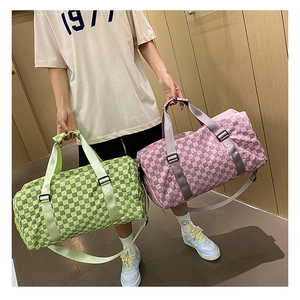 Model showcasing two large checkered travel bags in vibrant lime green and pink colors