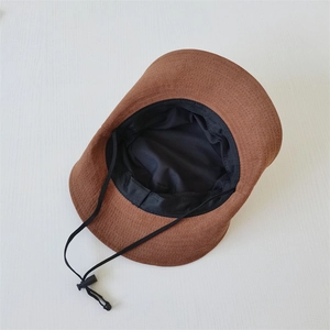 Close-up of brown outdoor hat fabric texture with adjustable black windproof drawstring