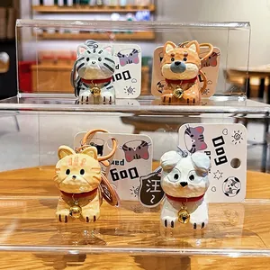 Set of four cute resin cat and dog keychains with golden bells on a wooden stand