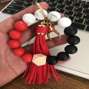 Close-up of silicone beaded wristlet keychain with marble beads and red leather tassel