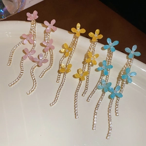 Detailed shot of resin flower tassel earrings in pink, yellow, and blue colors