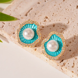 Gros plan de boucles d'oreilles coquillage avec émail bleu, perles et strass brillants
