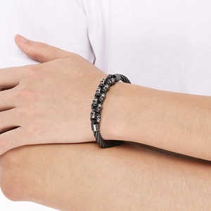 Close-up of men's skull cable bracelet on wrist with dark silver punk texture