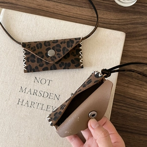 Detail view of leopard print purse pendant with white stitching and silver snap button