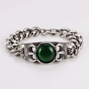 Macro shot of silver Cuban chain bracelet featuring a round green agate stone inlay