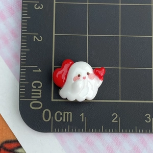 Mini resin ghost charm with red heart detail and ruler for precise size reference