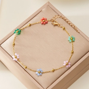 Detailed shot of colorful beaded flower bracelet with gold chain in a jewelry box