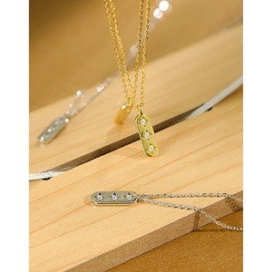 S925 Sterling Silver Star Zircon Necklace in Gold and Silver finish on a wooden stand