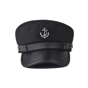 Close-up of nautical flat top cap with silver anchor badge and faux leather visor details