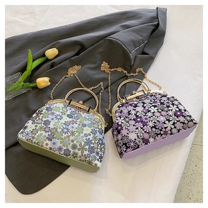 Detail of floral shell bags with gold kiss-lock frames and elegant chain straps