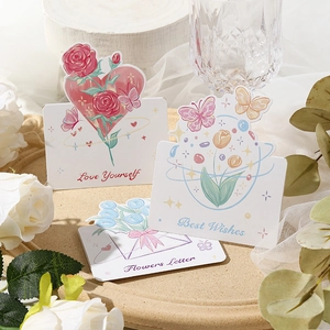 Detailed view of floral greeting cards with artistic illustrations on a wooden tray