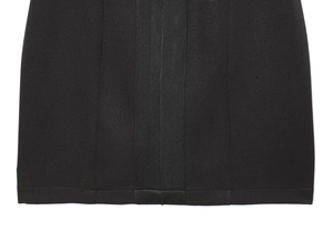 Detailed close-up of the double-needle hem and knit texture on the black bodycon dress
