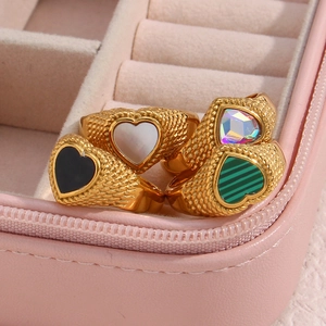 Detail of twisted 18K gold plated rings with colorful heart-shaped zircon in a jewelry box