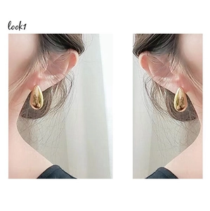 Detailed view of large gold teardrop earrings shown in mirror polish finish for women